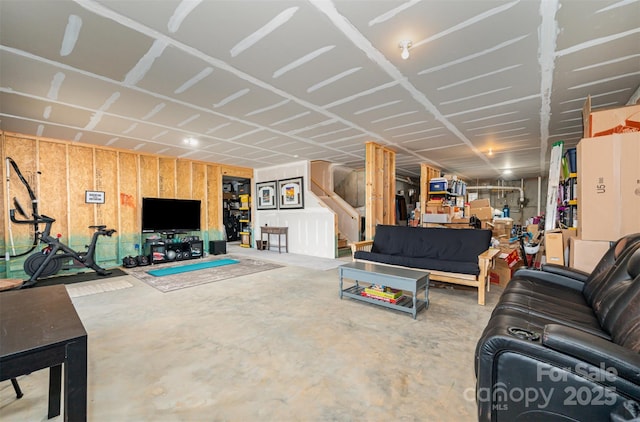 living area featuring stairway and concrete floors