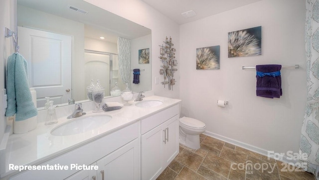 bathroom featuring vanity, toilet, and walk in shower