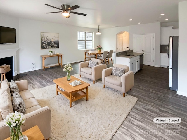 living room with sink, dark hardwood / wood-style floors, and ceiling fan