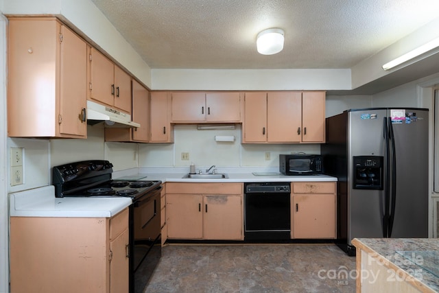 kitchen featuring under cabinet range hood, light brown cabinetry, black appliances, light countertops, and a sink