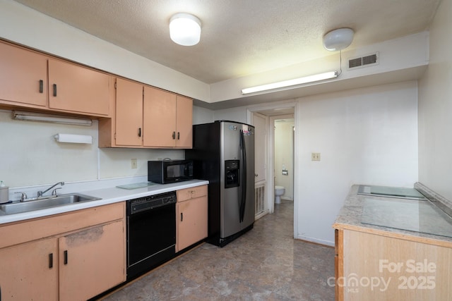 kitchen featuring visible vents, a sink, black appliances, and light countertops