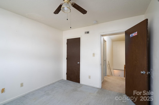 empty room with light carpet, a textured ceiling, and visible vents