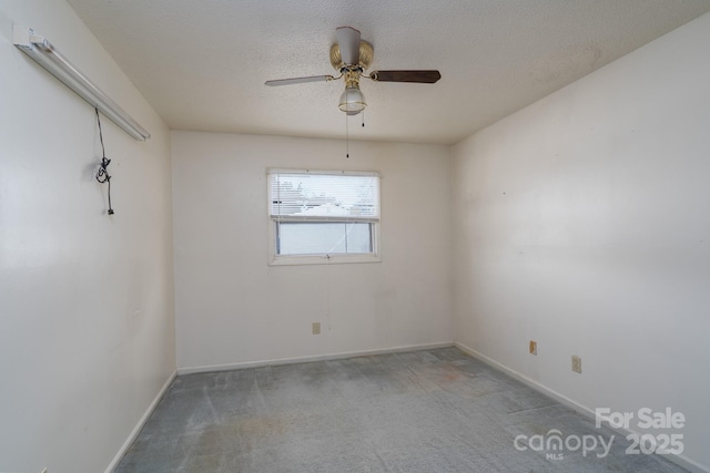 spare room featuring baseboards, a textured ceiling, a ceiling fan, and carpet