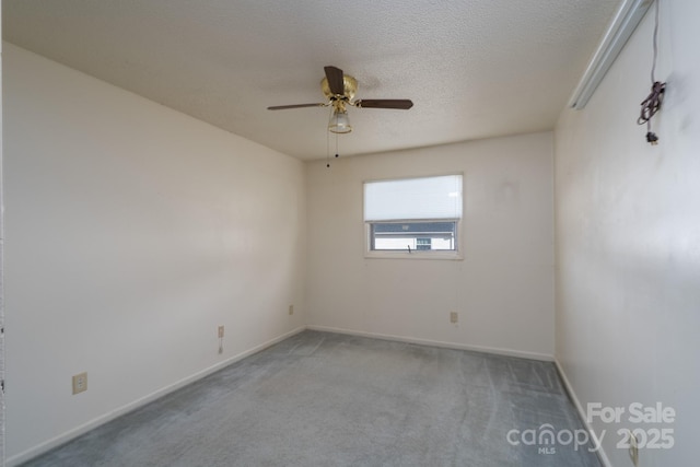 carpeted empty room featuring ceiling fan, a textured ceiling, and baseboards