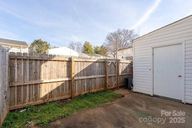 view of yard featuring fence, central air condition unit, and a patio area