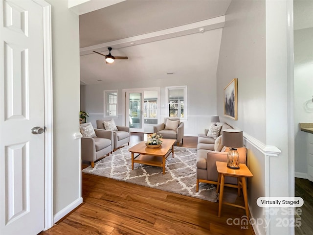 living room featuring ceiling fan, dark hardwood / wood-style floors, and vaulted ceiling with beams