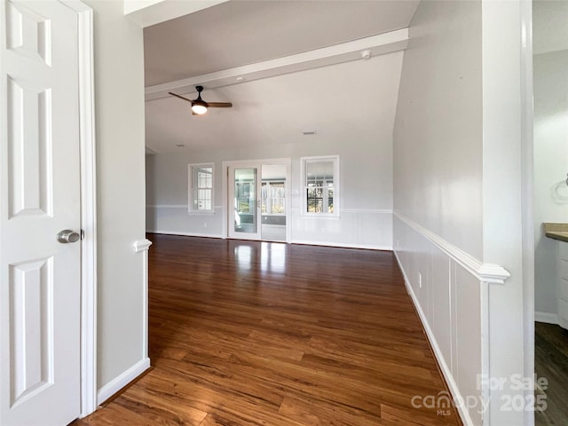 unfurnished living room with ceiling fan, dark hardwood / wood-style flooring, and lofted ceiling with beams