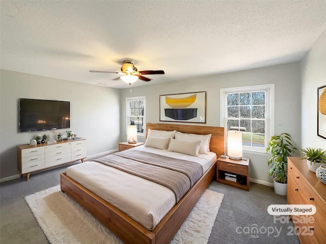 carpeted bedroom featuring ceiling fan and a textured ceiling