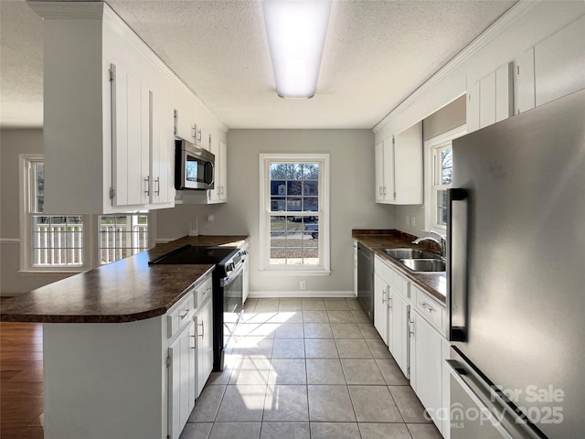 kitchen with white cabinetry, appliances with stainless steel finishes, sink, and kitchen peninsula