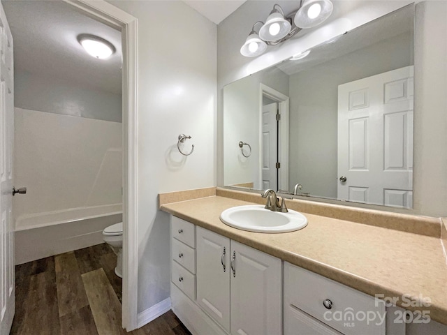 bathroom with hardwood / wood-style flooring, vanity, and toilet