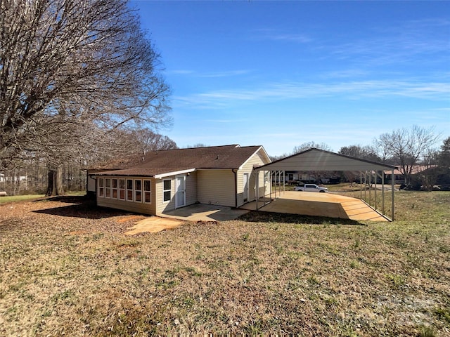 rear view of house featuring a carport and a lawn