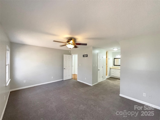 carpeted spare room featuring a textured ceiling and ceiling fan