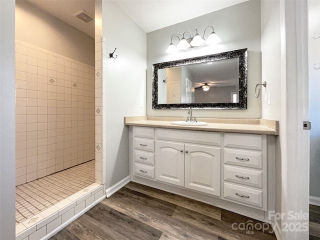 bathroom featuring a tile shower, vanity, and hardwood / wood-style flooring