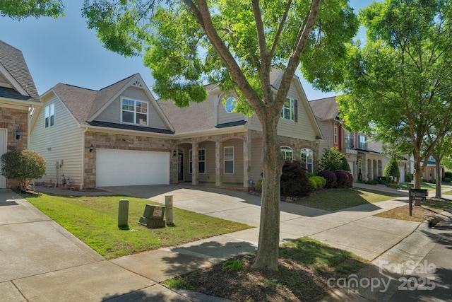 view of front of house with stone siding, concrete driveway, a front yard, and a garage