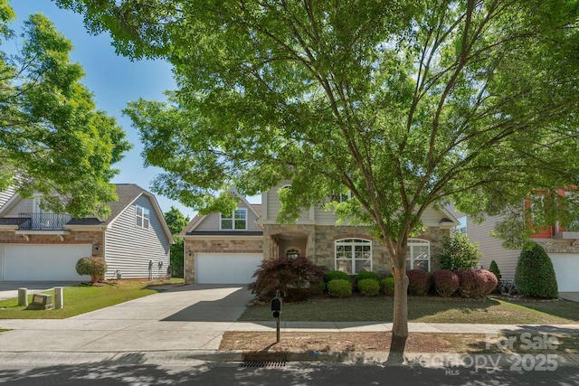 view of front of house featuring stone siding, concrete driveway, and an attached garage