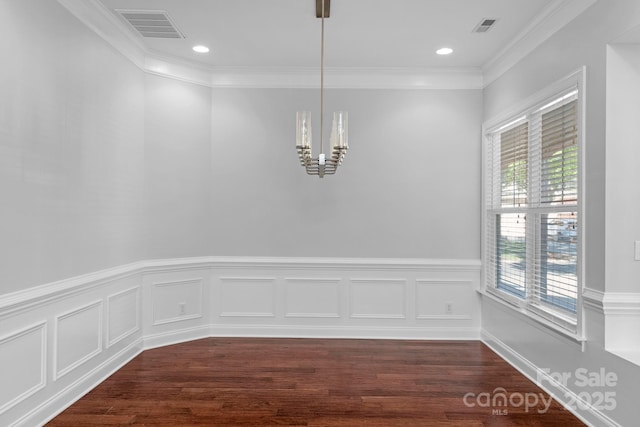unfurnished dining area with a chandelier, dark wood-type flooring, wainscoting, ornamental molding, and recessed lighting