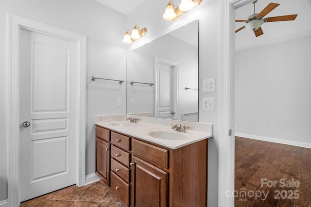 bathroom with a ceiling fan, double vanity, baseboards, and wood finished floors