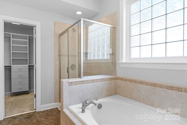 full bathroom with a stall shower, a spacious closet, a garden tub, and tile patterned floors