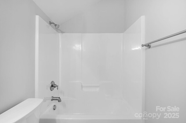 bathroom with toilet and washtub / shower combination