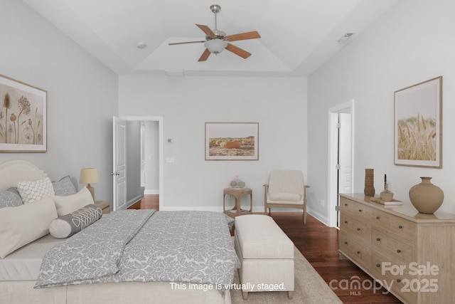 3009 Scottcrest Way, Waxhaw, NC 28173 - bedroom with dark wood-style floors, a tray ceiling, a ceiling fan, and baseboards