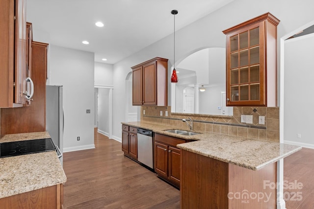 3009 Scottcrest Way, Waxhaw, NC 28173 - kitchen with appliances with stainless steel finishes, a sink, arched walkways, brown cabinets, and recessed lighting