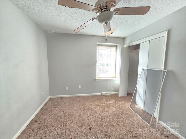 unfurnished bedroom featuring ceiling fan, carpet floors, a textured ceiling, and a closet