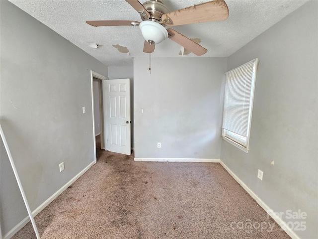 unfurnished room with ceiling fan, carpet flooring, and a textured ceiling