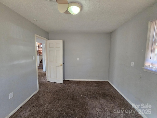 carpeted spare room featuring a textured ceiling