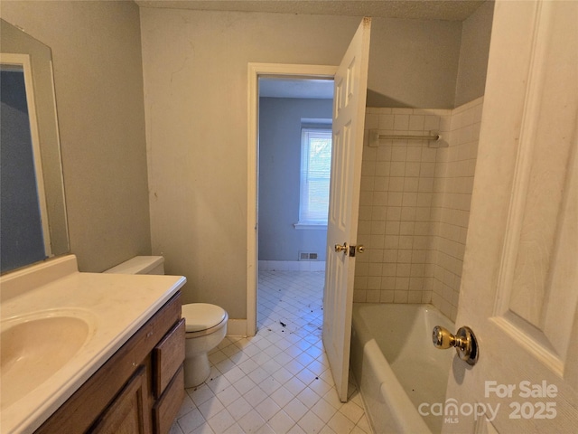 bathroom featuring vanity, a bath, tile patterned floors, and toilet