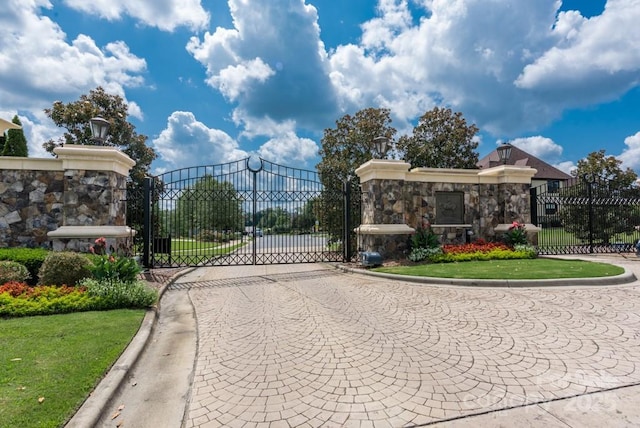 view of road featuring a gate, curbs, and a gated entry