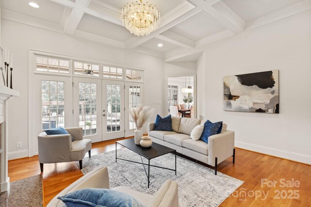 living area with baseboards, wood finished floors, and french doors