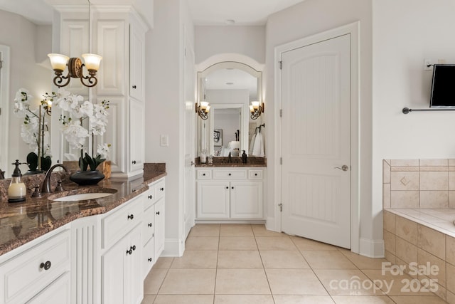 full bathroom with a bath, two vanities, a sink, and tile patterned floors