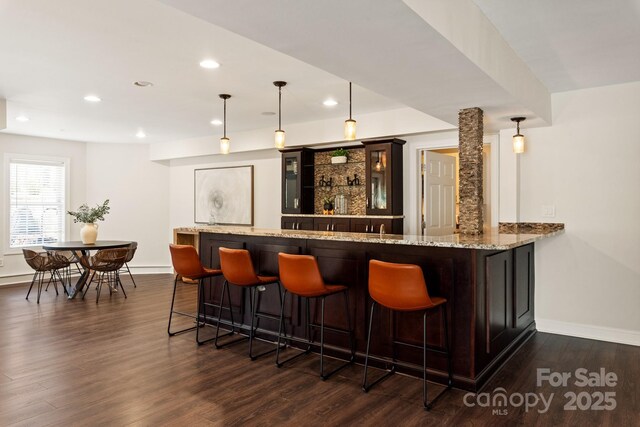 bar with baseboards, dark wood-style floors, hanging light fixtures, indoor wet bar, and recessed lighting