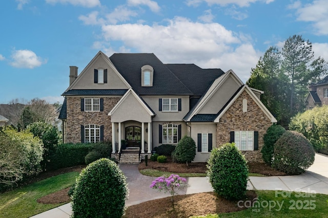 view of front of property featuring stone siding, stucco siding, and french doors