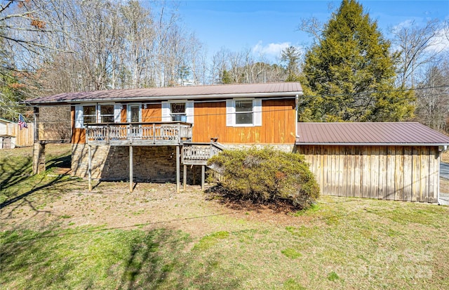 exterior space with metal roof, a lawn, and a deck