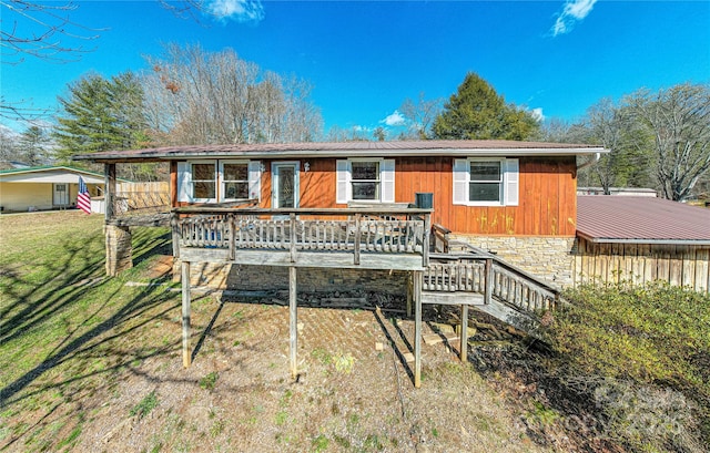 view of front of property featuring stairs, a deck, and a front yard