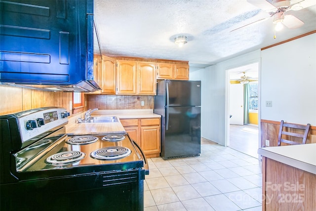 kitchen with electric range, ceiling fan, freestanding refrigerator, light countertops, and a sink