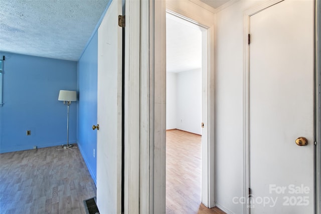 laundry room featuring light wood finished floors, visible vents, and a textured ceiling