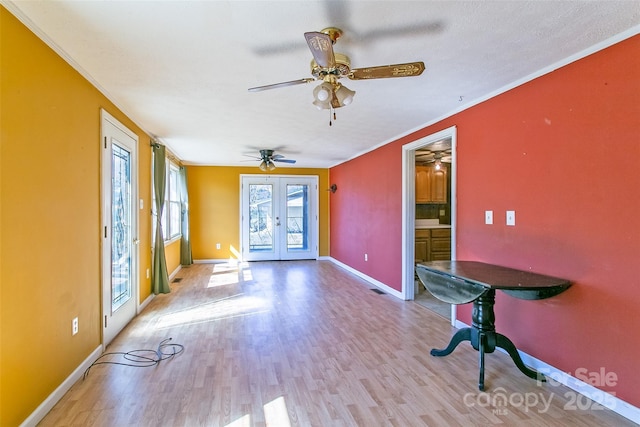 unfurnished room with light wood finished floors, french doors, baseboards, and crown molding