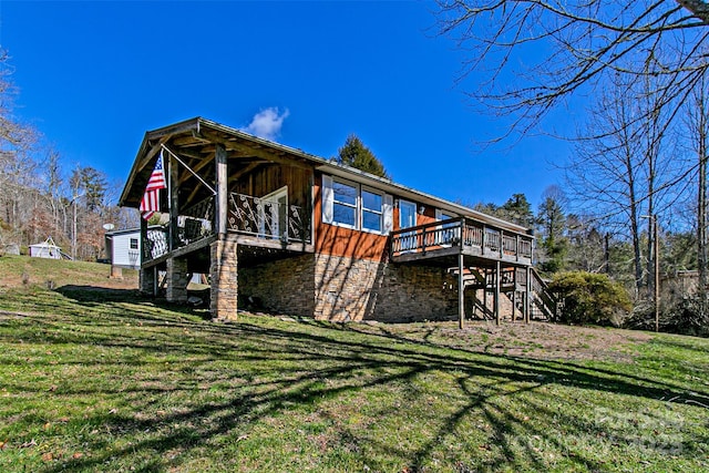 rear view of house with a yard, stairway, and a wooden deck