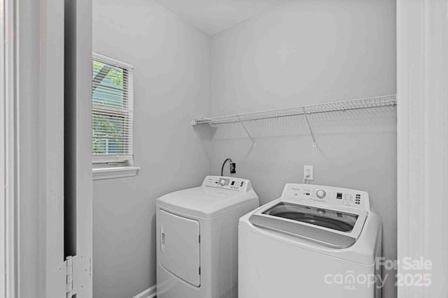 clothes washing area with separate washer and dryer