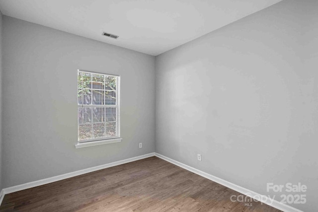 unfurnished room with dark wood-type flooring