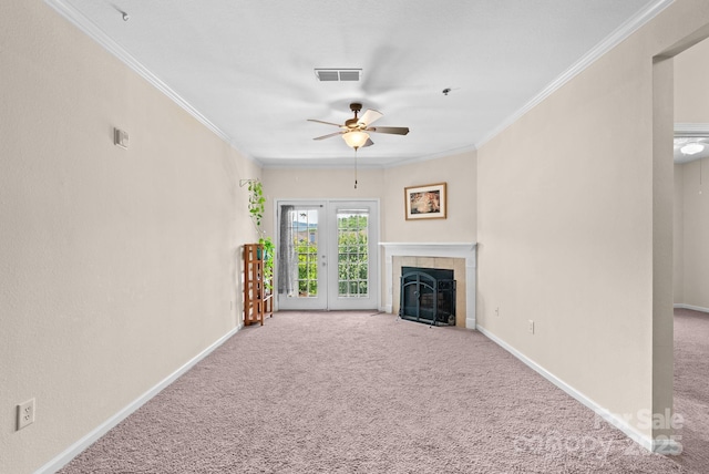 unfurnished living room with a tile fireplace, carpet floors, ceiling fan, and crown molding