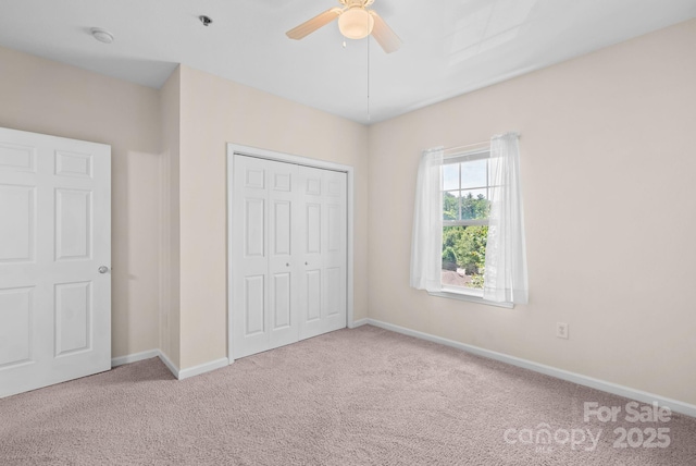 unfurnished bedroom featuring ceiling fan, light colored carpet, and a closet