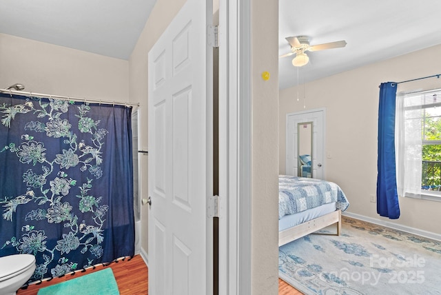 bathroom featuring ceiling fan, wood-type flooring, shower / bath combination with curtain, and toilet