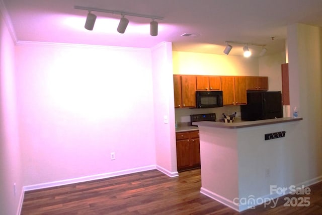 kitchen featuring dark hardwood / wood-style flooring, black appliances, and kitchen peninsula