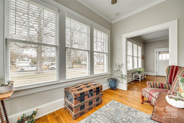 sitting room with hardwood / wood-style flooring and ornamental molding