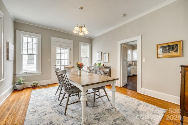 dining room with ornamental molding, a chandelier, and light wood-type flooring