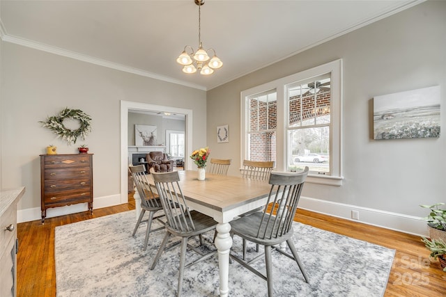 dining room featuring an inviting chandelier, hardwood / wood-style flooring, and ornamental molding