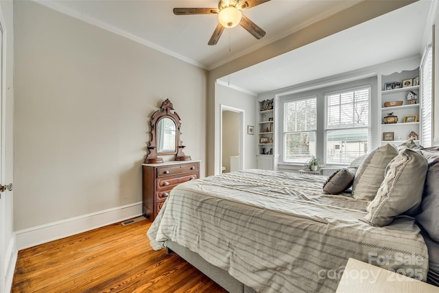 bedroom with crown molding, ceiling fan, and wood-type flooring